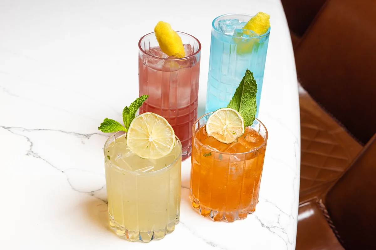 Four cocktails photographed at PSC with their garnishes