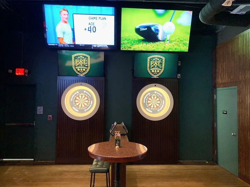 Two digital dartboards in PSC’s green-walled darts area