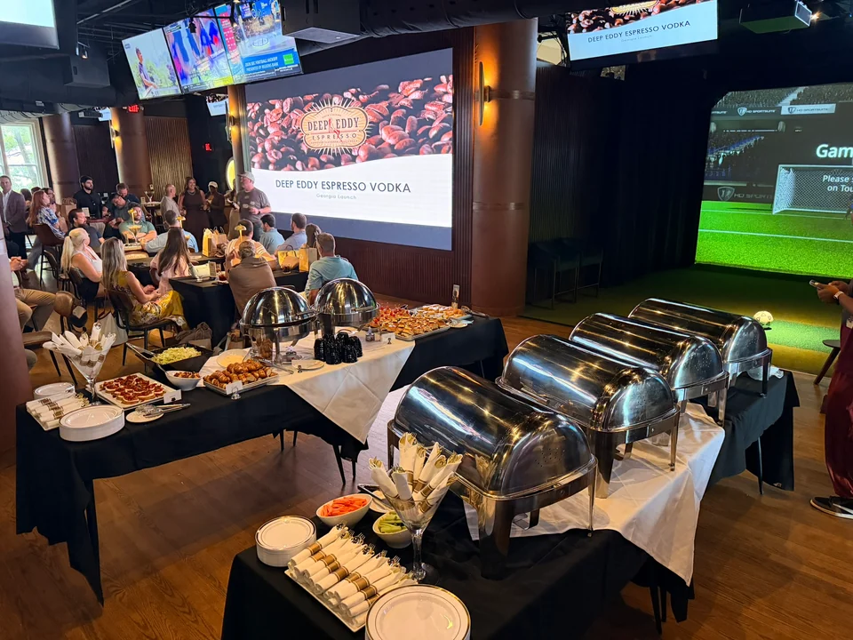 A catered PSC event with buffet tables, guests and presentation screens