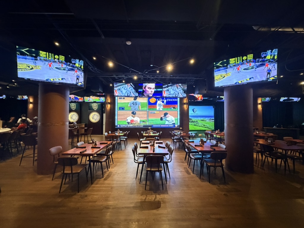 Tables facing the video wall and sports screens at Peachtree Sporting Club