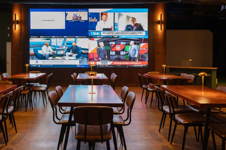 Dining tables face the main video wall at Peachtree Sporting Club