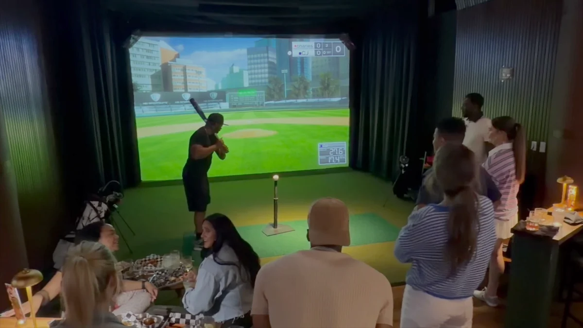 A baseball player and friends watching and talking in a PSC sports suite