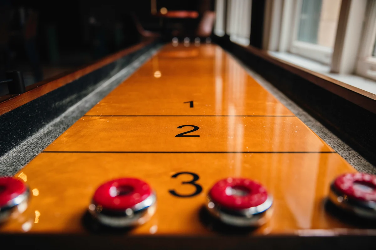 The PSC shuffleboard table with green lounge seating beyond